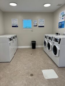 A laundry room with three washers